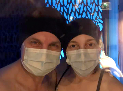 Portrait d’un couple avec un maque et un bonnet lors d’une séance de cryothérapie corps entier en duo pour soulager les douleurs et les inflammations